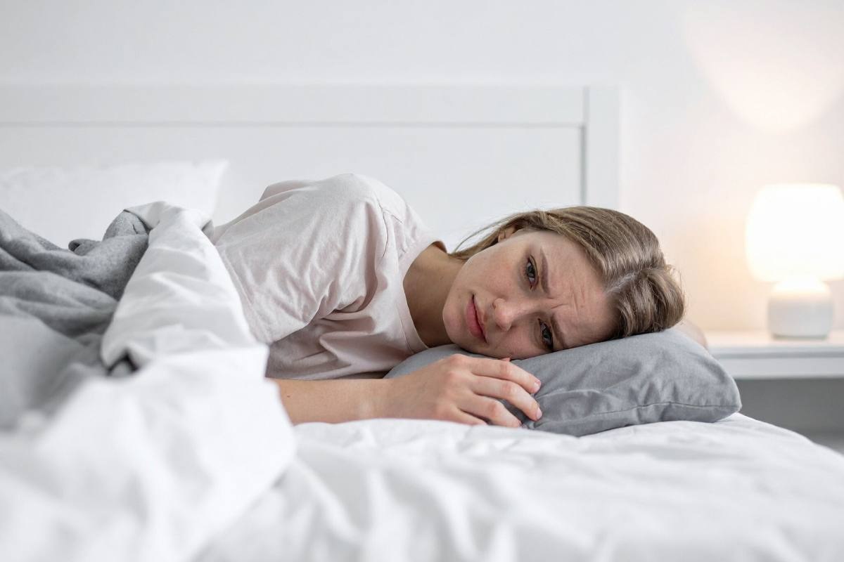 ragazza stese nel letto pensierosa